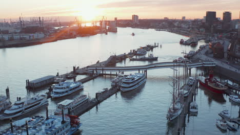 Aerial-view-of-sunset-in-Hamburg-harbor-with-anchored-yachts-and-sailing-boats-on-the-river-Elbe