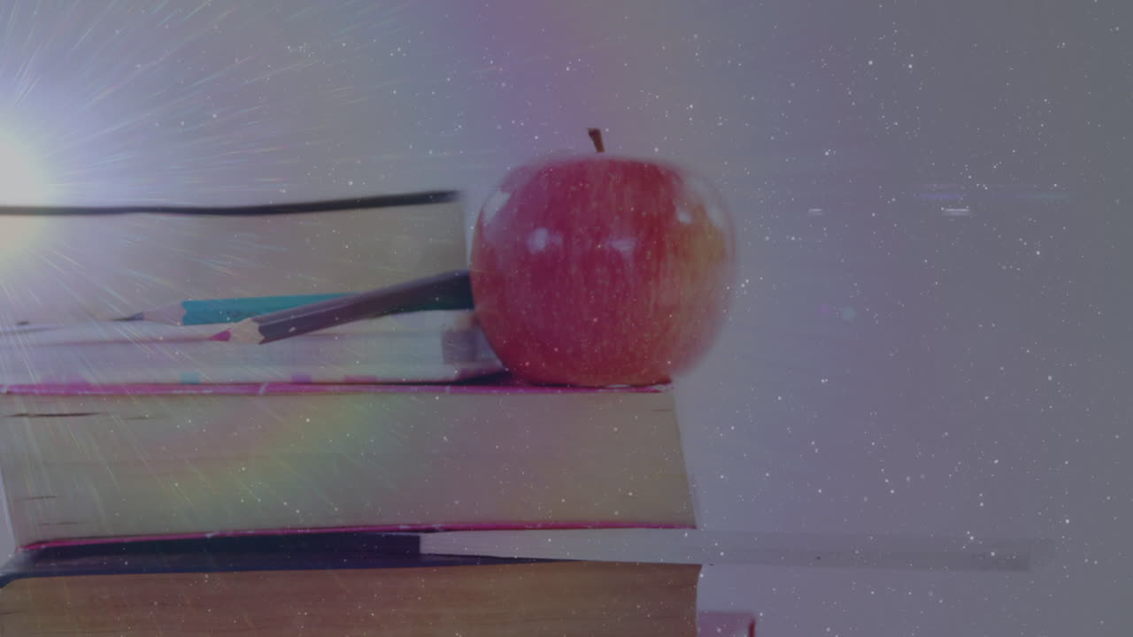 Animation of light spot over books and apple on white background