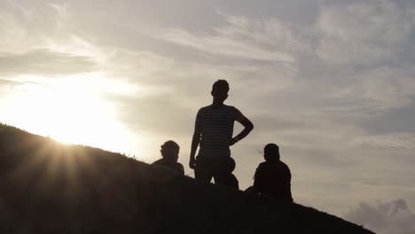 silhouette of a happy family relaxing on the open grass field in galle fort evening sun glare, consept of a vacation and family time