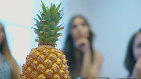 piña con cima verde contra las mujeres tranquilas borrosas