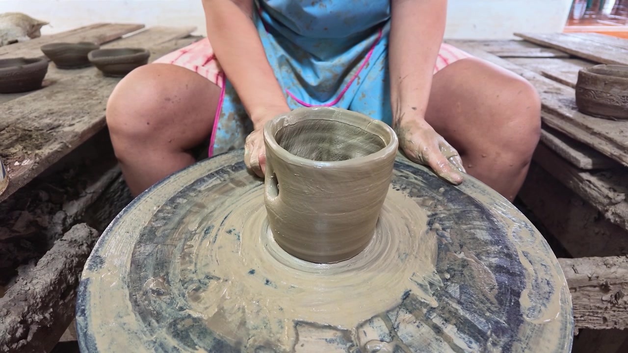 Mani artigiane modellano argilla umida su un tornio a Koh Kret, Nonthaburi, Thailandia.