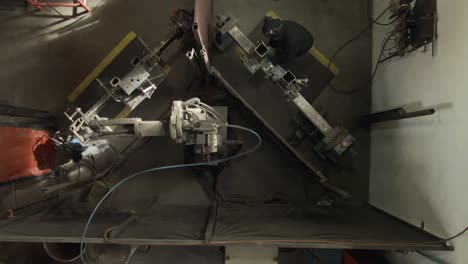 imagen aérea de 4k de una máquina robótica de soldadura con un hombre trabajando a su lado