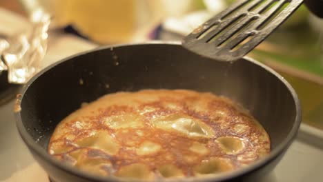 flipping a finnish style pancake to fry it on the otherside on a hot pan