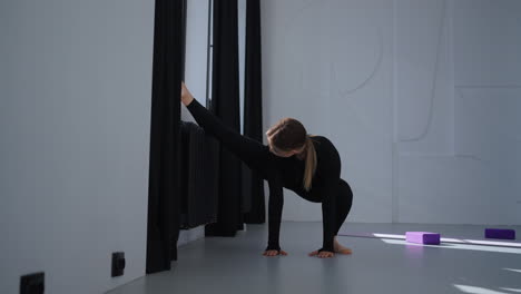 woman doing yoga stretches in a studio