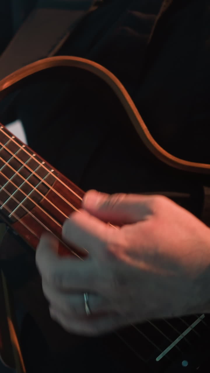 guitarrista sin rostro con una camisa negra tocando la guitarra contra un fondo gris. el primer plano captura los detalles intrincados de la guitarra y las manos del músico