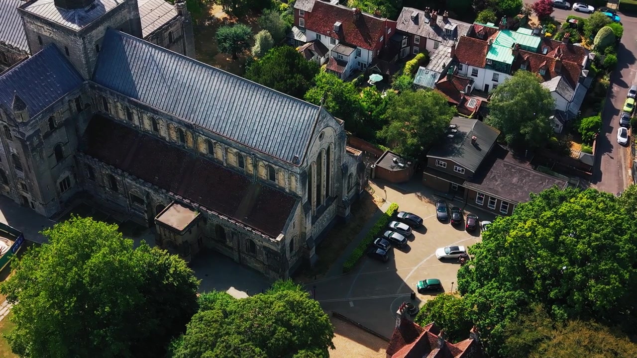 Droneoptagelse over Romsey Abbeys korafslutning og taglinje, med udsigt over en parkeringsplads og omkringliggende huse