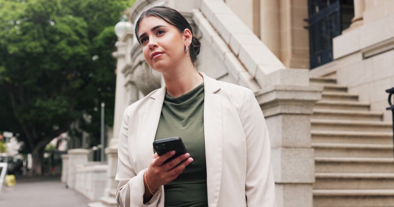 Donna professionista che usa lo smartphone fuori da un edificio per uffici