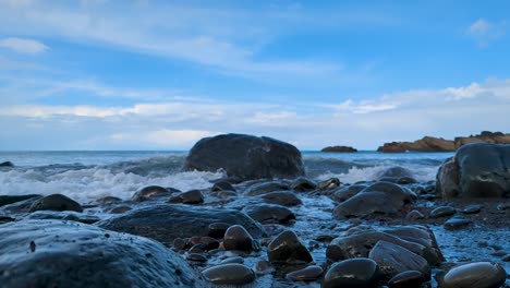 Dramatische-Welle-Trifft-Einsamen-Felsen-Am-Felsigen-Strand---Weite-Landschaft