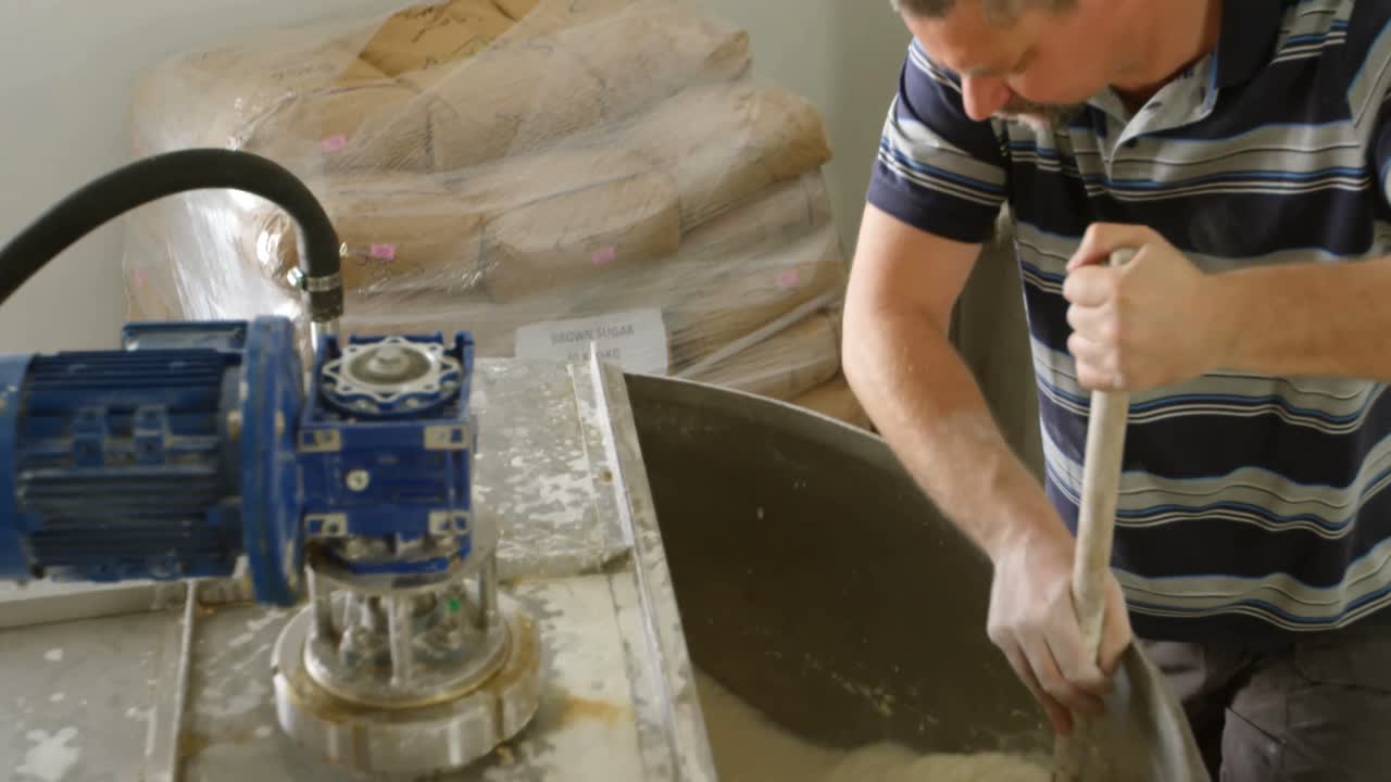 trabajador masculino mezclando ginebra en la destilería 4k