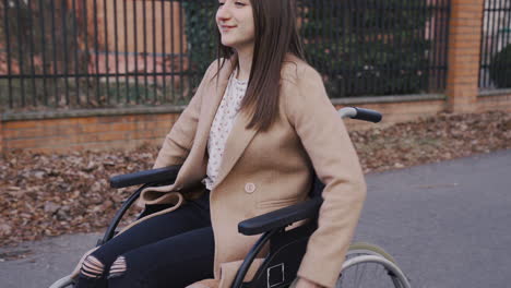 mujer discapacitada girando las ruedas de su silla de ruedas para dar un paseo por la ciudad 1