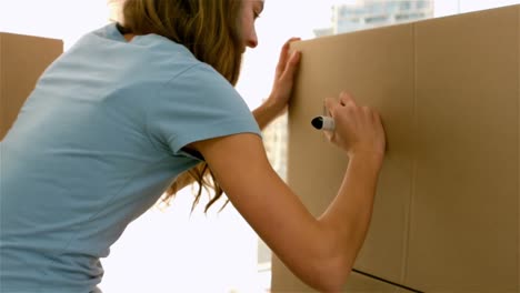 una chica bonita escribiendo en una caja