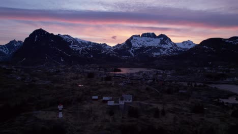 Aerial-establishing-shot-of-Sorvagen-in-Lofoten-Norway-at-sunset-in-late-April-as-the-polar-night-ends-above-the-arctic-circle