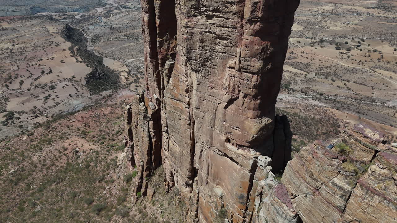 Veduta aerea dei Monti Gheralta, che mostra imponenti formazioni rocciose e un terreno antico nella regione del Tigrè in Etiopia. Persone che camminano su una scogliera.