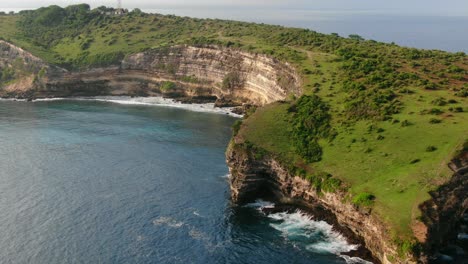 Vista-Aérea-Que-Avanza,-Hierba-Verde-Y-árboles-En-La-Cima-Del-Acantilado-De-Tanjung-Ringgit