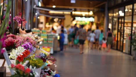 shoppers pass by a vibrant flower stall