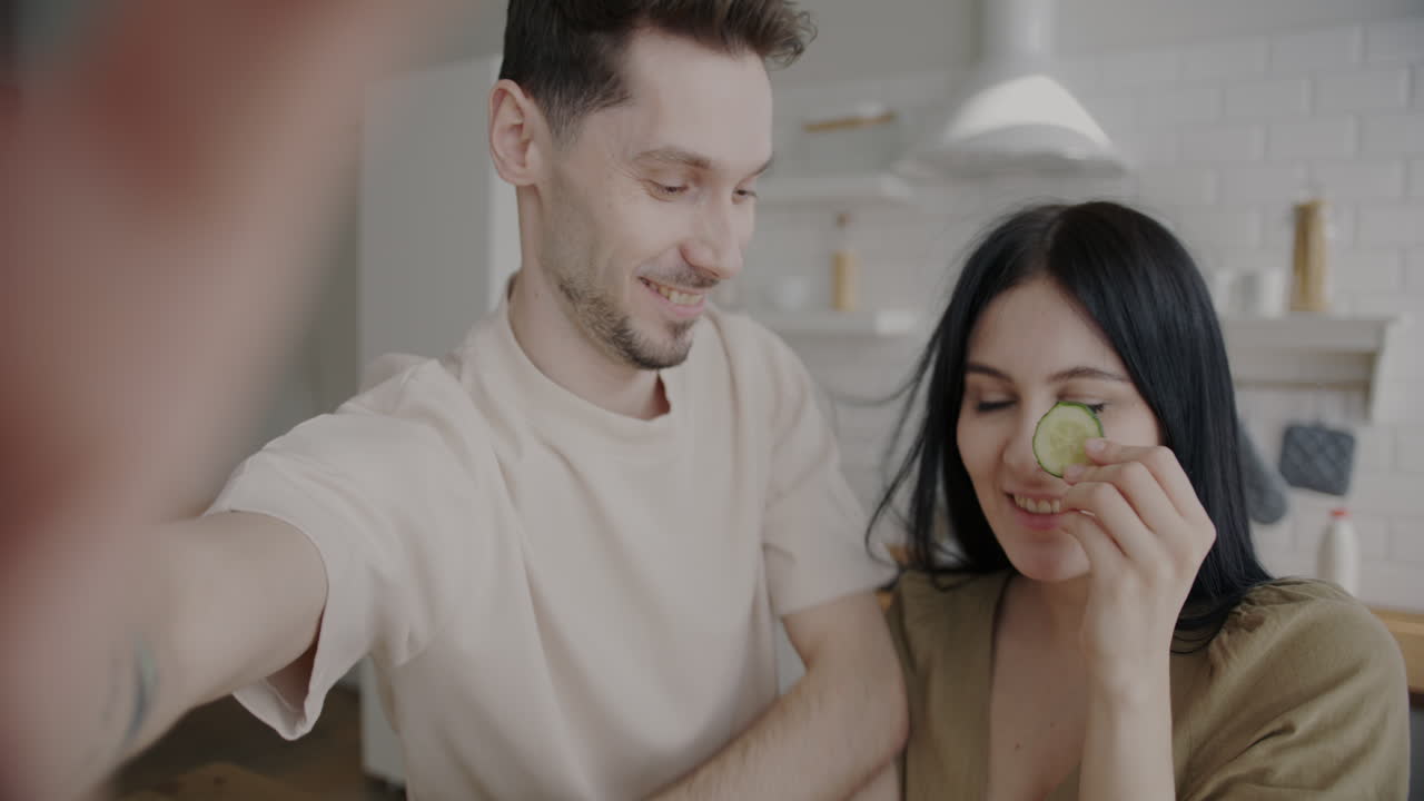 Couple Taking a Selfie with Cucumbers on Eyes
