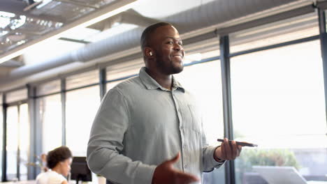 african american young man holding smartphone, appearing confident and engaged