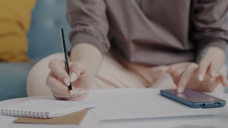 woman taking notes at home