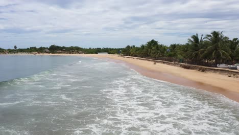 vuelo aéreo a baja altitud rápidamente sobre el océano y las olas en el popular destino de surf de la bahía de arugam, sri lanka