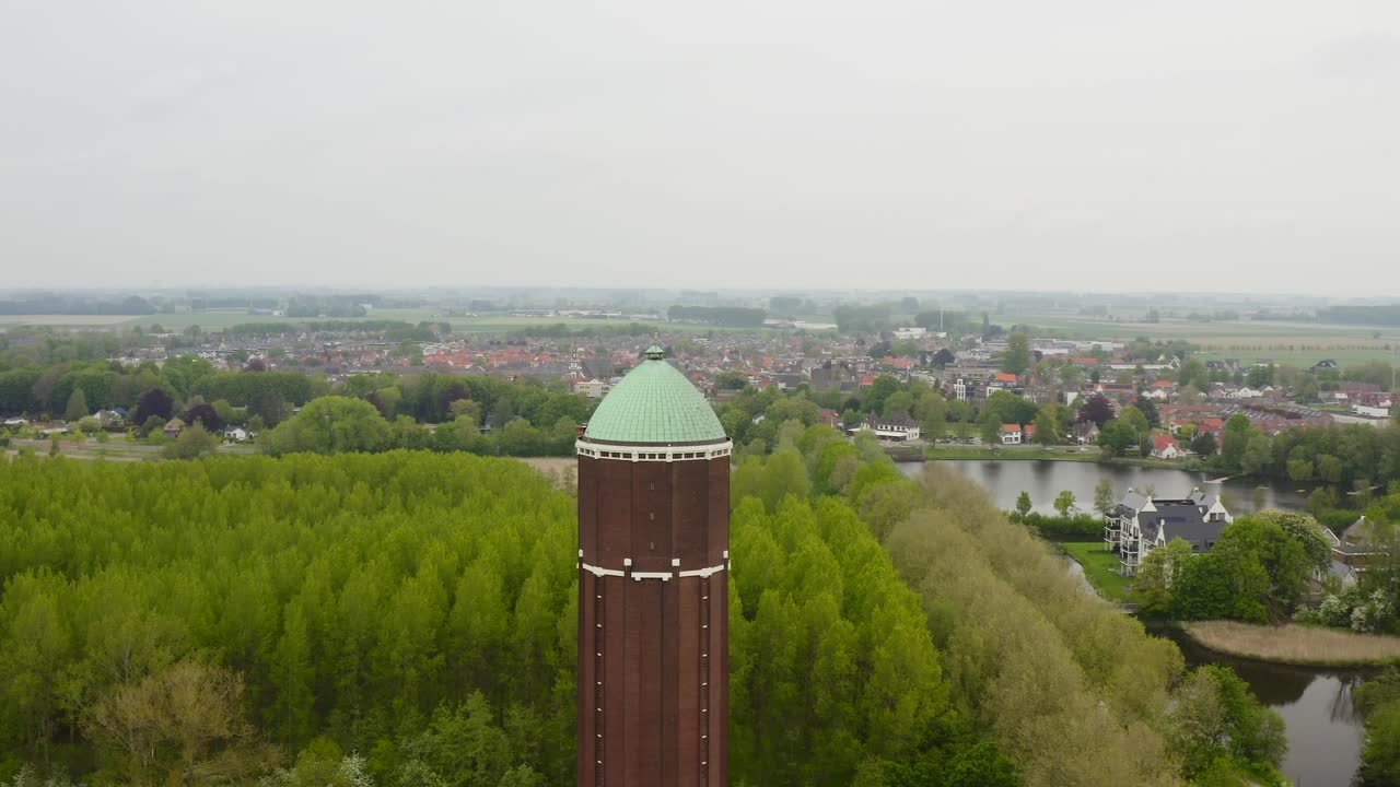 Aerial orbit over the famous water tower in the city of Axel shot on a cloudy day with city in background