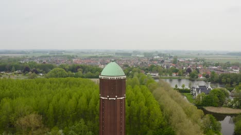 órbita-Aérea-Sobre-La-Famosa-Torre-De-Agua-En-La-Ciudad-De-Axel-Filmada-En-Un-Día-Nublado-Con-La-Ciudad-En-Segundo-Plano