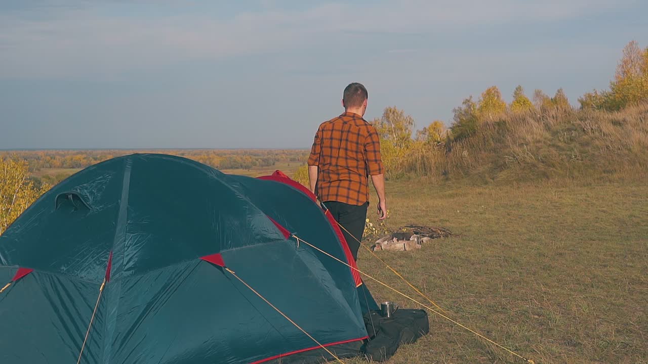 체크 셔츠를 입은 남자가 들판에서 천천히 밖으로 나갑니다.