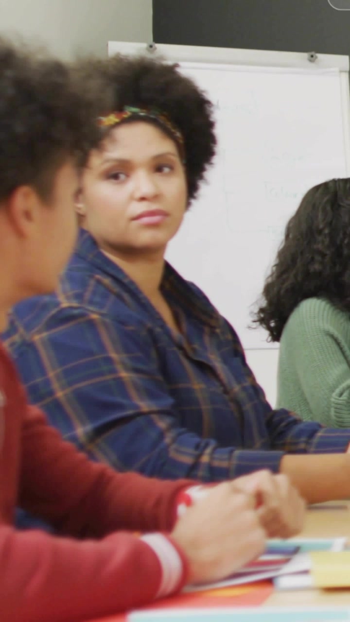 Vertical video: Workshop woman raising finger asking question as notifications animating over team