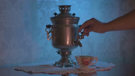 pouring hot water from a soviet vintage samovar electric metal tea kettle into a gorgeous cup-3