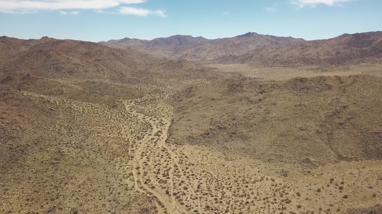 toma aérea de drones del desierto seco en el parque nacional joshua tree durante el día soleado con cielo azul en california, estados unidos