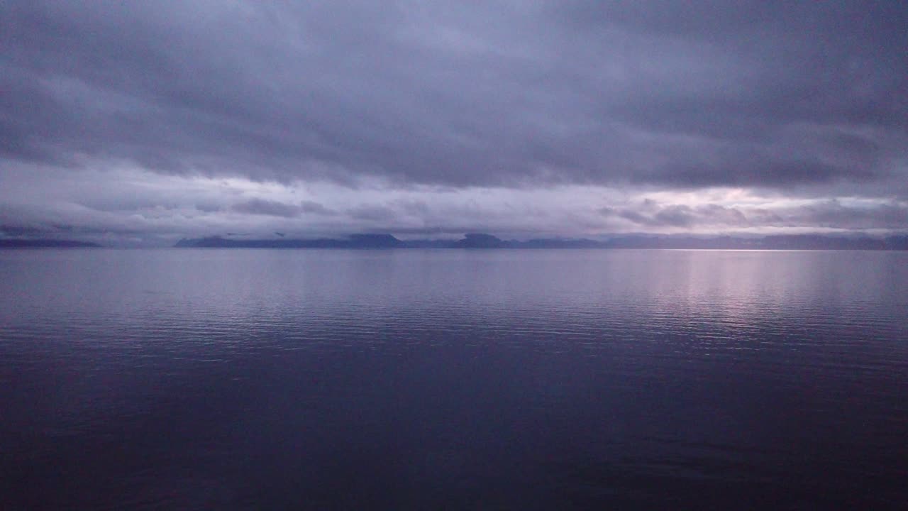 Vast Ocean with Distant Mountains under a Muted Sky