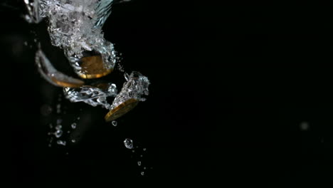 monedas de euro que caen al agua