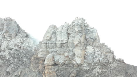 antena de gran roca en la cima de la montaña rodeada de niebla espesa