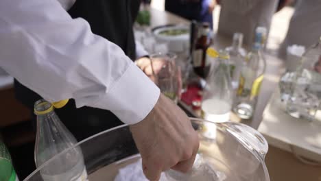 bartender preparing a drink with ice, lime, and mint, seen from a close-up perspective