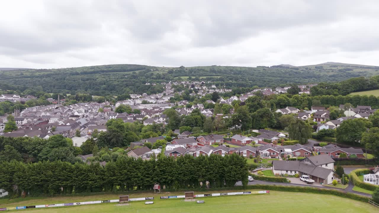 revelación aérea de casas residenciales en okehampton, reino unido, que muestra una mezcla de casas y áreas verdes dentro de la ciudad