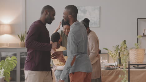 a happy family gathering with two brothers shaking hands
