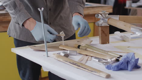 close up of male craftsman in workshop assembling hand built sustainable bamboo bicycle frame