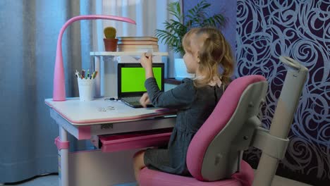 niño preescolar niña alumna aprendizaje a distancia en línea en casa, escuchando lecciones de audio, haciendo tareas