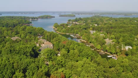 drone dolly a la derecha que muestra árboles, casas y costa en el lago norman, carolina del norte