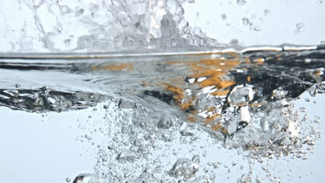 Fruits-immersed-bubbled-water-closeup.-Raw-food-making-splashes-inside-glass