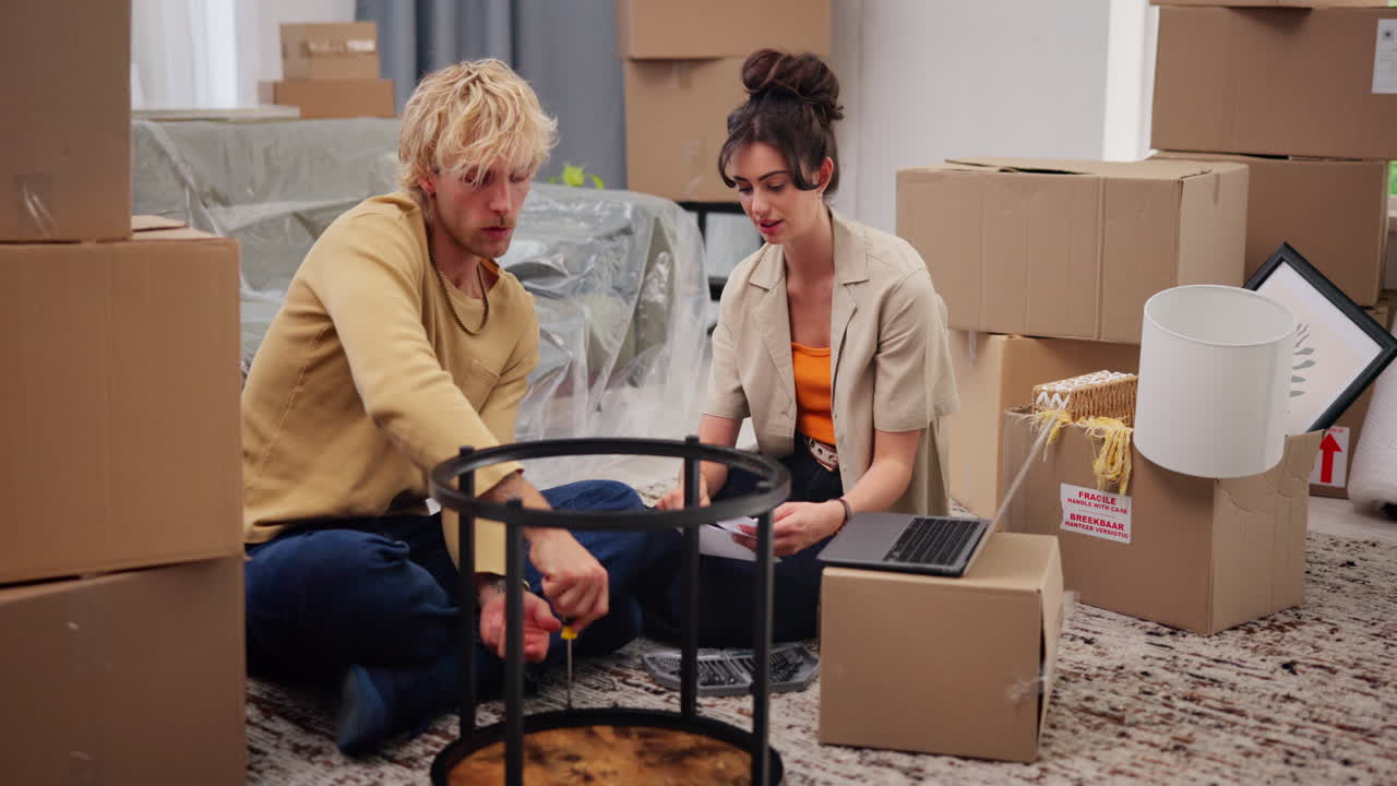 Happy Couple Assembling Furniture in New Home Surrounded by Moving Boxes