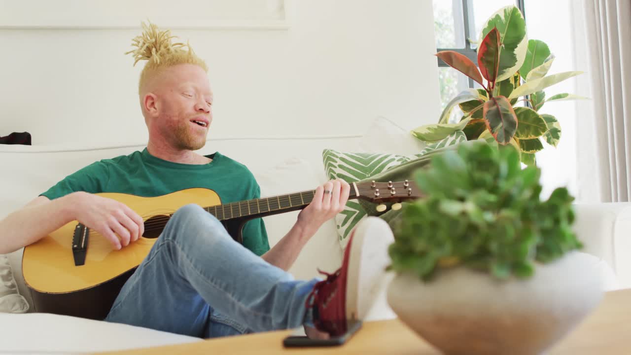 hombre albino afroamericano con rastas tocando la guitarra y cantando