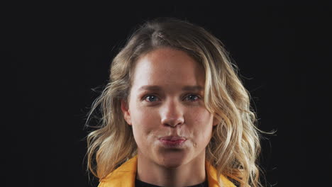 close up head and shoulders studio shot of woman laughing at camera in slow motion