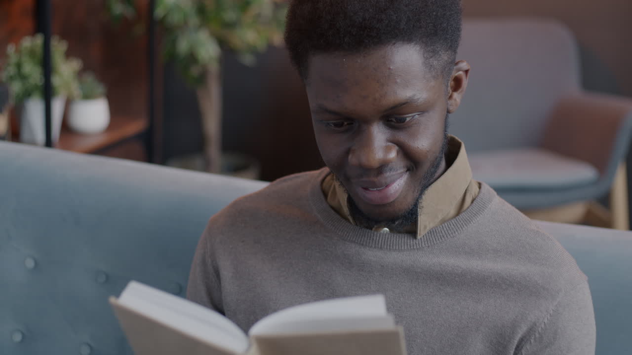 Uomo che legge un libro su un divano