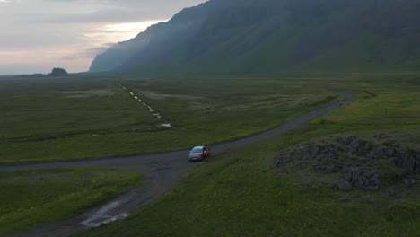 Birds-eye-orbit-view-of-four-by-four-off-road-car-parked-in-grassy-highland-of-Iceland.-Aerial-view-rental-car-parked-at-stunning-countryside-in-south-Iceland