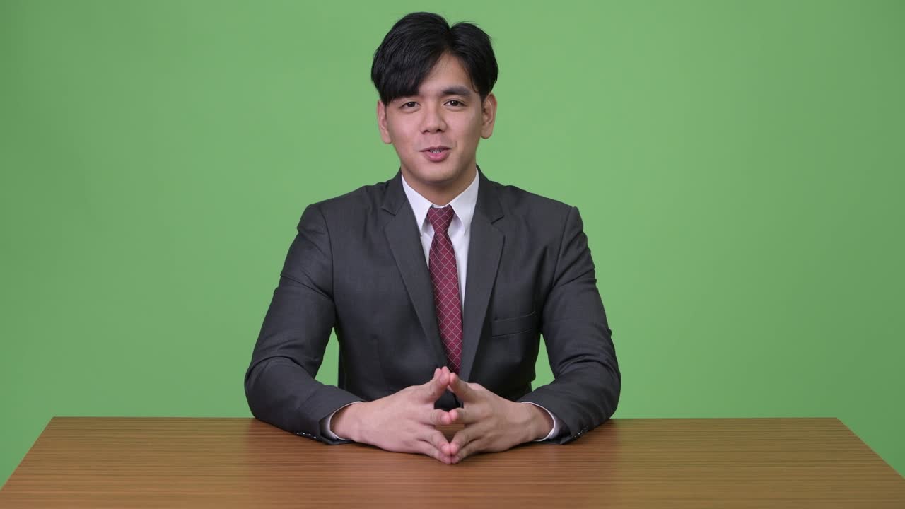 녹색 배경에 젊은 잘생긴 아시아 사업가