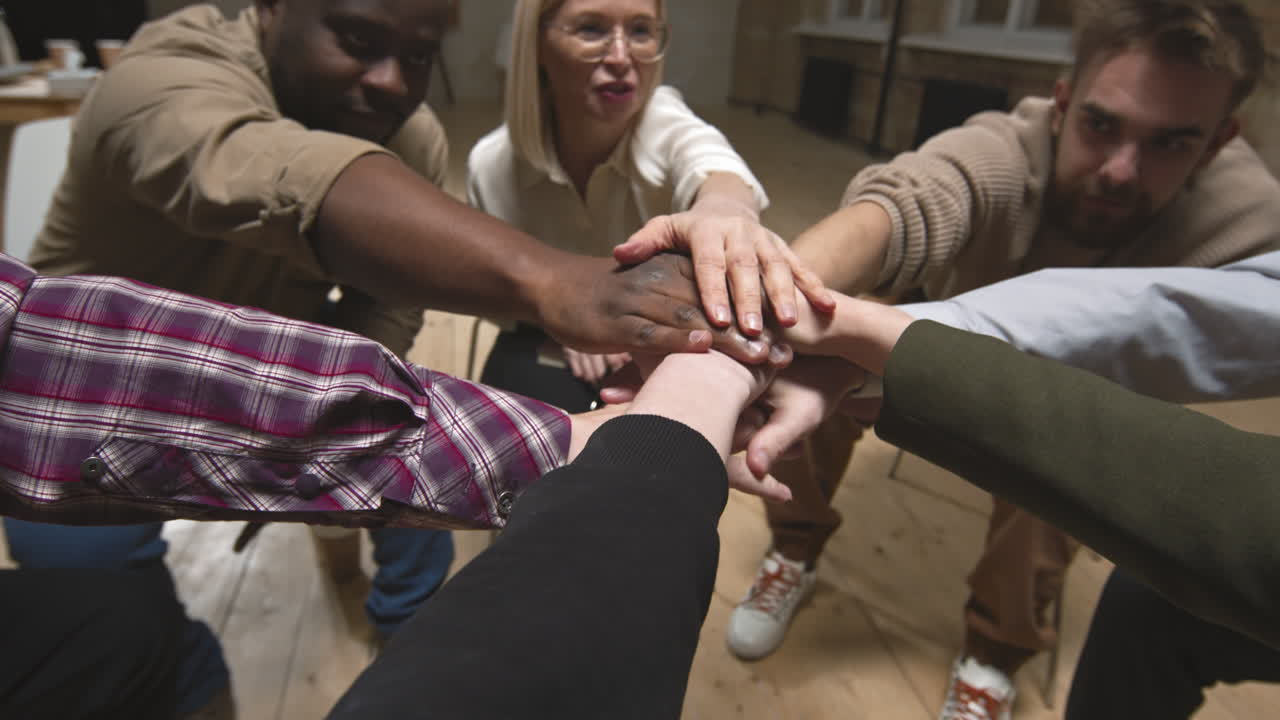 People Holding Hands Together in Middle at Support Meeting