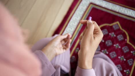 muslim woman praying with prayer beads