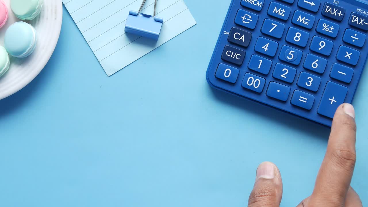 calculadora azul en el escritorio con macarrones