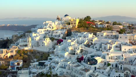 Vista-Aérea-Del-Pueblo-De-Imerovigli-Se-Asienta-Sobre-Un-Acantilado-Iluminado-Por-Las-Primeras-Luces-De-La-Mañana,-Santorini