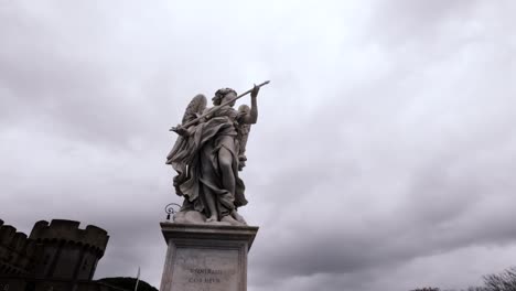 Angel Marble Statue From The Sant'Angelo Bridge During Cloudy Day In Rome, Italy. Low Angle Shot
